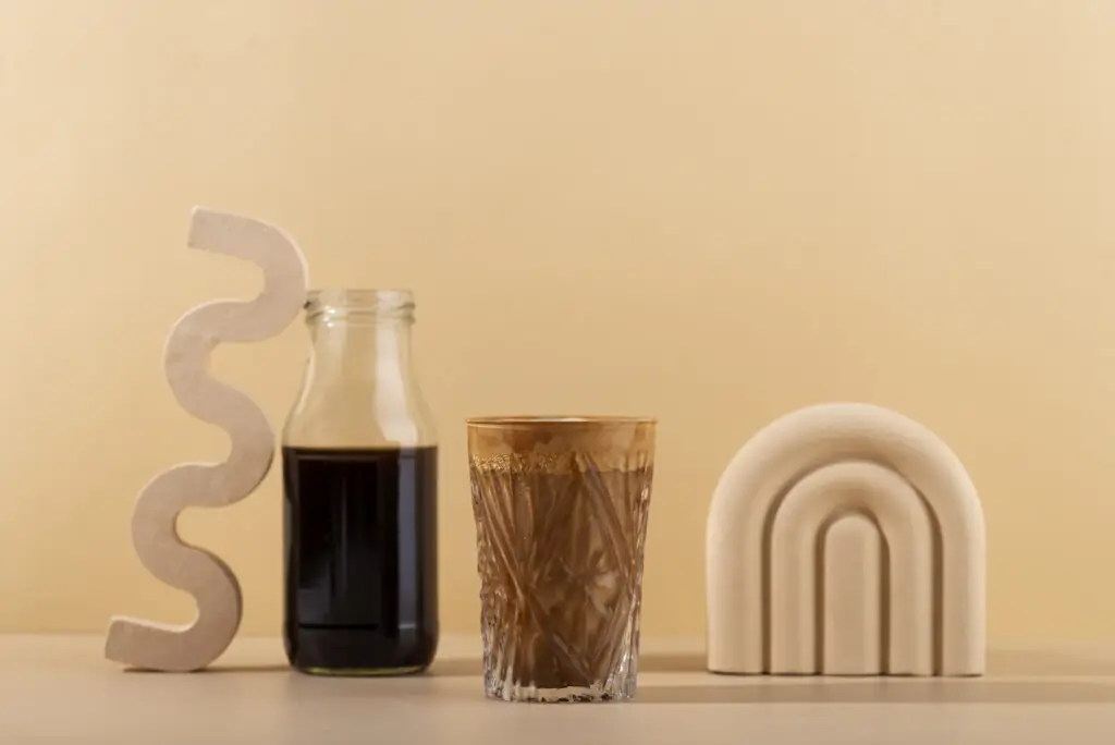 Latas PET transparentes con café frío, cold brew y matcha latte en una cafetería moderna.